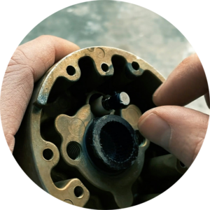 hands repairing a component on a small engine